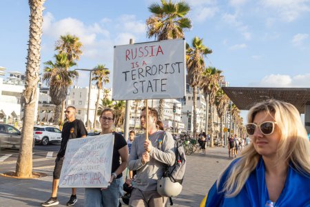 Photo for Tel Aviv, Israel - March 20, 2022, Protest against Russian aggression in Ukraine. A man and a woman with a poster - Russia is a terrorist state. Today Russia bombed Vinnitsa - Royalty Free Image