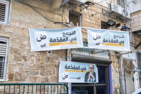 Téléchargez les photos : Akko, Israël - 01 novembre 2022, affiches électorales avec des candidats des partis arabes sur le mur de la maison - en image libre de droit