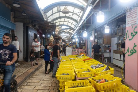 Foto de Acre, Israel - 01 de noviembre 2022, Mercado de pescado en un día libre. Diferentes variedades de pescado fresco en cajas con hielo. Los vendedores venden a los compradores - Imagen libre de derechos