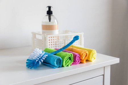 Mehrfarbige Fasertücher zum Staubwischen und eine Kunststoffbürste
