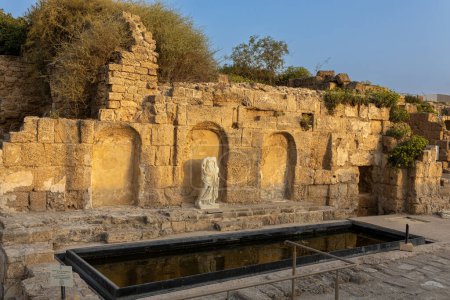 Photo for CAESAREA, Israel - August 2022, Roman emperor statue reflecting in a pool, Numerous tourists visit ruins fortress built by Herod the Great near Caesarea city, on the shores of the Mediterranean Sea - Royalty Free Image
