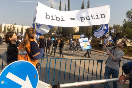 Foto de JERUSALEM, ISRAEL - 20 de febrero de 2023: Los israelíes protestan cerca de la Knesset contra los planes del primer ministro Benjamin Netanyahu de pisotear la ley. Placard - Bibi es Putin - Imagen libre de derechos