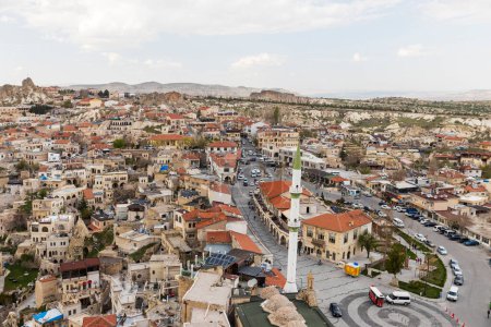 Foto de Capadocia, Turquía - 24 de abril de 2024, Vista de la ciudad de Ortahisar con el minarete de la mezquita en primer plano y el valle de Capadocia en el fondo cerca de la ciudad de Goreme, - Imagen libre de derechos