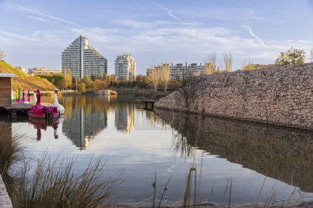 Valencia, Spain. Park in the former riverbed of the Turia River. Early spring. Building. Plastic pink and white swans in an amusement park. Sunset.
