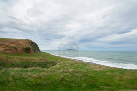 Photo for Green Cliffs at Gemstone beach in the Te Waewae Bay with view of Pahia point at distance, Orepuki, The Catlins, Southland, New Zealan - Royalty Free Image
