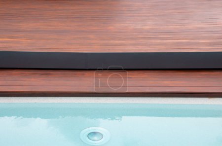 Photo for Detail of swimming pool coping and cover constructed by cumaru wood deck, hardwood decking texture next water - Royalty Free Image