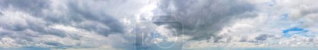Téléchargez les photos : Panorama de nuages gris foncé contraste magnifiquement avec le ciel bleu, Fond du ciel. - en image libre de droit