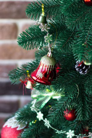 Téléchargez les photos : Des cloches rouges sur un sapin de Noël. Arbre de Noël. Atmosphère festive - en image libre de droit