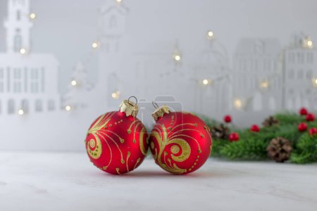 Téléchargez les photos : Carte de Noël avec ballons rouges sur le fond d'une ville en bois avec une guirlande - en image libre de droit