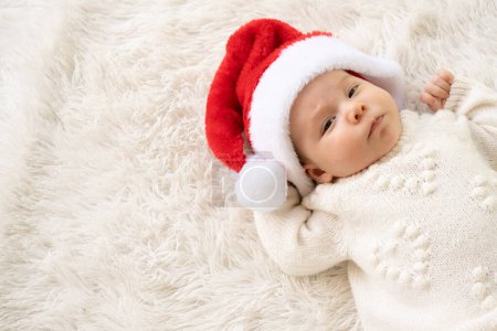 Foto de Retrato de Navidad de la niña recién nacida linda, usando sombrero de santa y abrazando pequeño muñeco de nieve lindo juguete, tiempo de invierno - Imagen libre de derechos