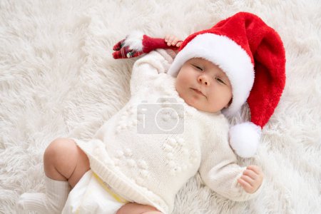 Foto de Retrato de Navidad de la niña recién nacida linda, usando sombrero de santa y abrazando pequeño muñeco de nieve lindo juguete, tiempo de invierno - Imagen libre de derechos