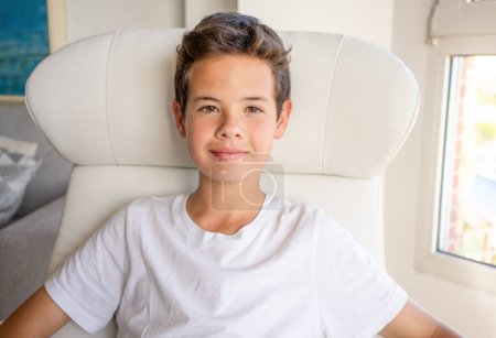 Foto de Retrato de un adolescente sonriente sentado en un sofá en casa - Imagen libre de derechos