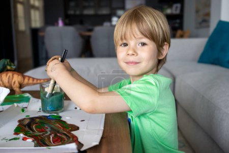 Foto de El niño pinta la actividad creativa en casa. Pintura artística de niño - Imagen libre de derechos