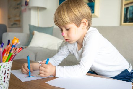 Child boy drawing at home