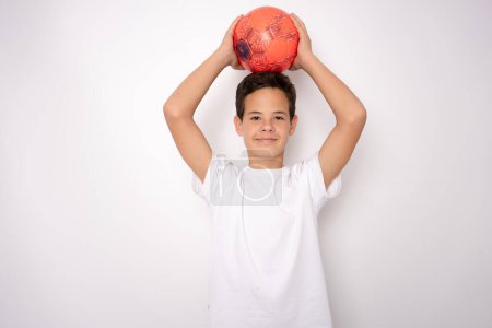 Téléchargez les photos : Sourire adolescent garçon dans sportswear tenant ballon de football - en image libre de droit