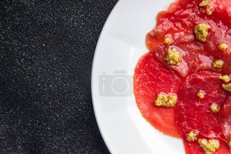 carpaccio spice meat raw appetizer olives, beef thin slices fresh healthy meal food snack on the table copy space food background rustic top view