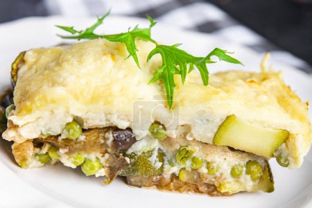 vegetables casserole eggplant, zucchini, green peas, cheese, bechamel sauce vegetable lasagne healthy meal food snack on the table copy space food background rustic top view keto or paleo diet veggie