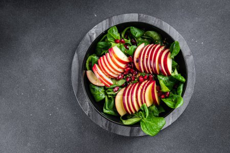 Photo for Apple salad, green mix lettuce, pomegranate grain healthy meal food snack on the table copy space food background rustic top view keto or paleo diet veggie vegan or vegetarian food - Royalty Free Image