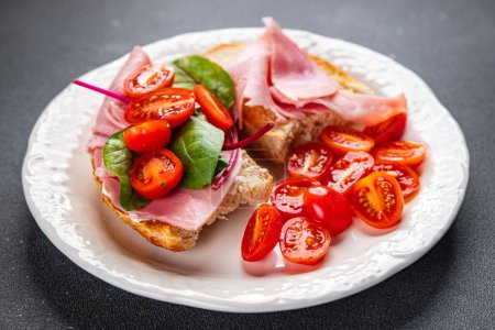 Sandwich-Schinken, Tomaten, Salat Bruschetta Snack bereit für gesunde Mahlzeit Lebensmittel Snack auf dem Tisch kopieren Raum Lebensmittel Hintergrund rustikale Ansicht von oben