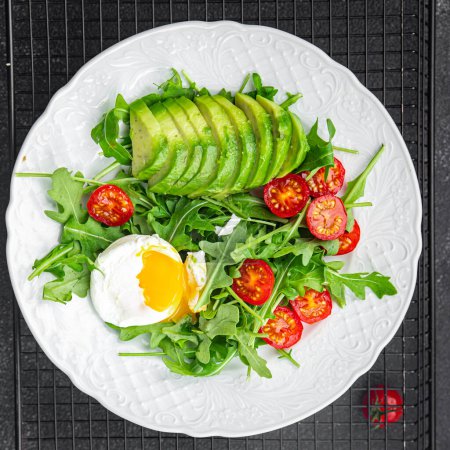Photo for Avocado salad poached egg, arugula, tomato, green salad leaves healthy meal food snack on the table copy space food background rustic top view keto or paleo diet veggie vegan or vegetarian food - Royalty Free Image