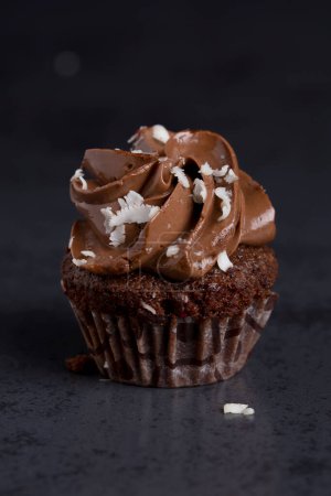 Ein luxuriöser Schokoladen-Cupcake mit reichem Zuckerguss und weißen Schokoladenspänen.