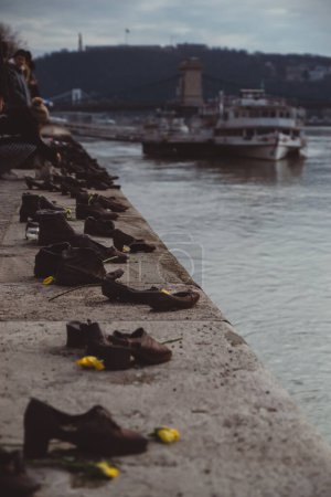 Foto de BUDAPEST, HUNGRÍA - 28 de febrero de 2022: "Zapatos en la orilla del Danubio" - Monumento en memoria de las víctimas del Holocausto durante la Segunda Guerra Mundial en la orilla del río Danubio. - Imagen libre de derechos