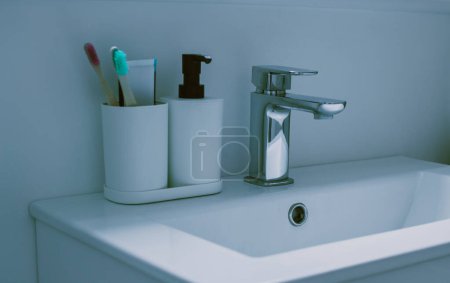 Téléchargez les photos : Fond de bain minimal avec brosses à dents en bambou en verre plastique blanc sur fond blanc. Vue de face. Espace de copie. Photo de haute qualité dans les tons verts bleus. - en image libre de droit