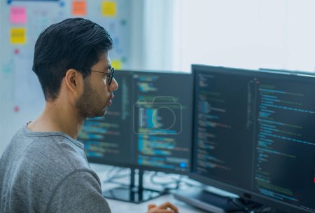 Téléchargez les photos : Asiatique promt ingénieur développer application de codage avec des données logicielles assis devant moniteur d'ordinateur au bureau - en image libre de droit