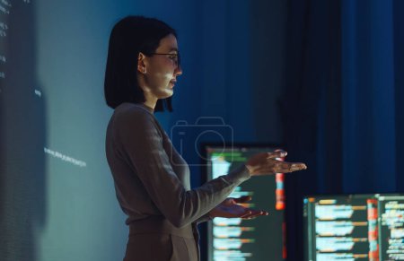 Foto de Asiático mujer desarrollador presentación acerca de la codificación de datos de software con devops equipo en la noche en la oficina - Imagen libre de derechos