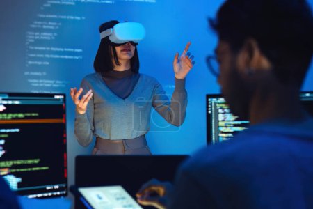 Foto de Asiático e indio desarrollador devops equipo prueba virtual realidad codificación y presentación con ai prompt en la noche en oficina - Imagen libre de derechos