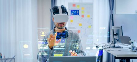Téléchargez les photos : Asian and Indian developer program coding sent to virtual reality headset to implement ai project at office - en image libre de droit