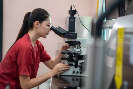 Asian woman scientists or researchers using a microscope to check bull's sperm. Research concept in a laboratory or hospital. medical science laboratory of the Department of Livestock Development.
