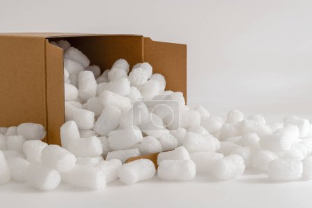 Cardboard box isolated on the white background filled with packing peanuts