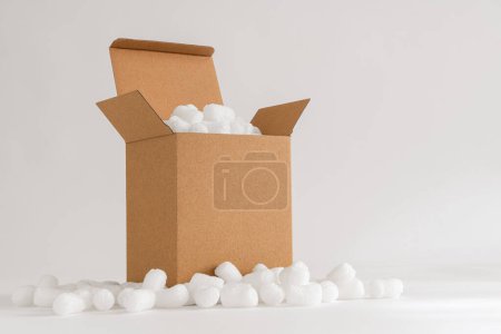 Cardboard box isolated on the white background filled with packing peanuts