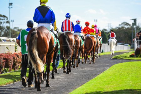 Photo for Horses and jockeys parading in the paddock before the race - Royalty Free Image