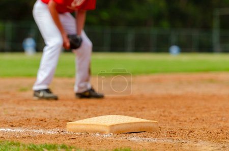 Foto de Primer plano de la tercera base de béisbol y una línea sucia con campo de hierba en el fondo. Béisbol diamante de cerca. - Imagen libre de derechos
