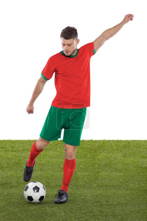 Foto de Jugador de fútbol profesional con camiseta roja de la selección de Marruecos a punto de marcar un gol con una expresión de desafío y decisión en su cara sobre fondo blanco. - Imagen libre de derechos