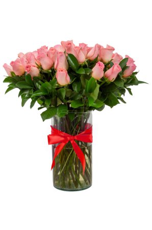 Jarrón de cristal con hermosas rosas rosadas flores con lazo rojo sobre fondo blanco.