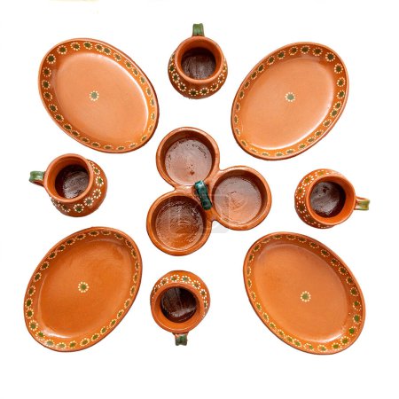 Photo for Tableware of several pieces of red clay made in Mexico. Traditional handmade Mexican clay crockery. isolated White background. - Royalty Free Image