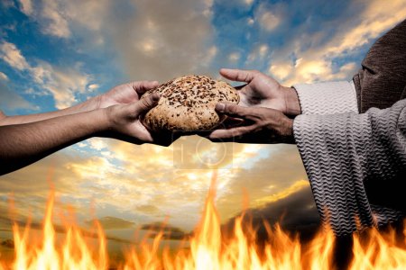 Téléchargez les photos : Hands of Jesus Christ giving someone a piece of artisan bread. Background of fire and cloudy sky. - en image libre de droit