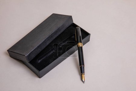 elegant metal fountain pen in black with gold details with black velvet case in low angle view