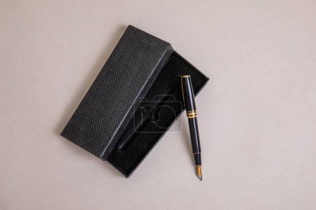 elegant metal fountain pen in black with gold details with black velvet case in overhead view