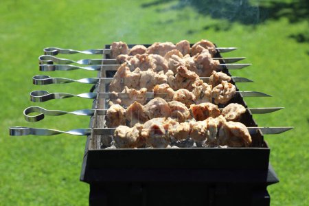 Foto de Carne marinada a la parrilla en pinchos - shashlik, preparada sobre carbón en una parrilla especial - Imagen libre de derechos