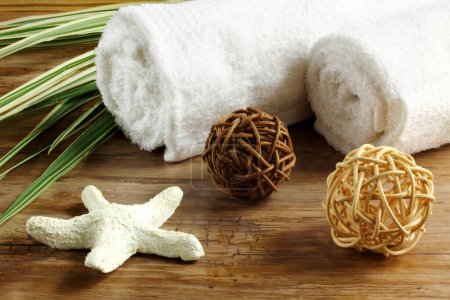 Photo for Spa, balneo, relaxation set - rolled towels with starfish, pedig spheres and bamboo leaves on wooden table - Royalty Free Image
