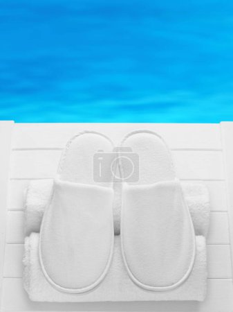 Foto de Balneo, spa, hotel, casa, zapatillas de bienestar con toallas enrolladas en el muelle con fondo de agua - verano, tiempo de sauna - espacio para el texto - Imagen libre de derechos