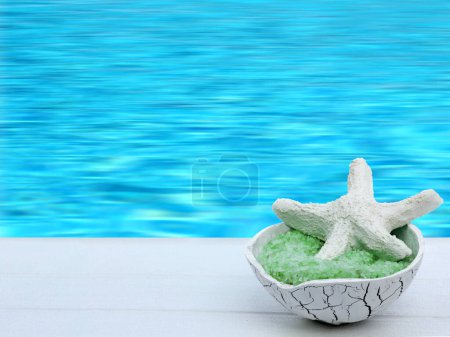 Téléchargez les photos : Étoile de mer et sel de bain dans un bol exotique sur jetée blanche / jetée avec fond de mer / eau - heure d'été, spa, balnéo, détente, bien-être - en image libre de droit