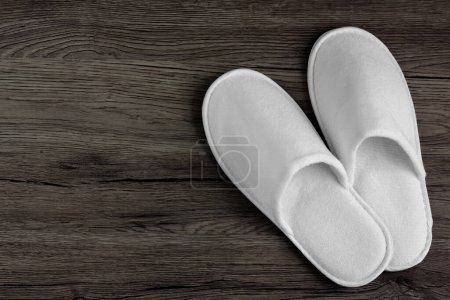 Photo for Spa, hotel - home slippers on wooden background with space for text - Royalty Free Image