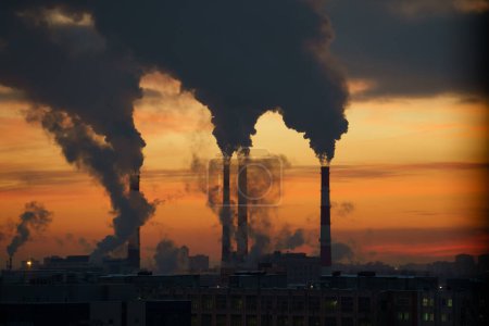 Factory, heating station or power plant pipes. Environment pollution in city. Skyline with smokestacks emitting carbon in air during winter heating season. Problem of harmful fuel usage in big city