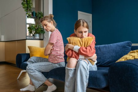 Photo for Upset teenage daughter and young woman mother sitting separately in silence on sofa at home, feeling frustrated after quarrel. Sad parent mom having misunderstandings with troubled teen girl child - Royalty Free Image