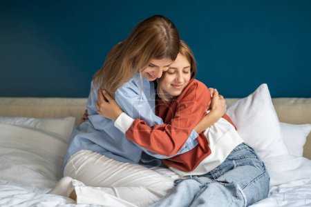 Photo for Pleased smiling teen girl hugging embrace mother show love gratitude affection close good relationship. Parent woman and daughter spend time together at home feeling supported protected from trouble. - Royalty Free Image